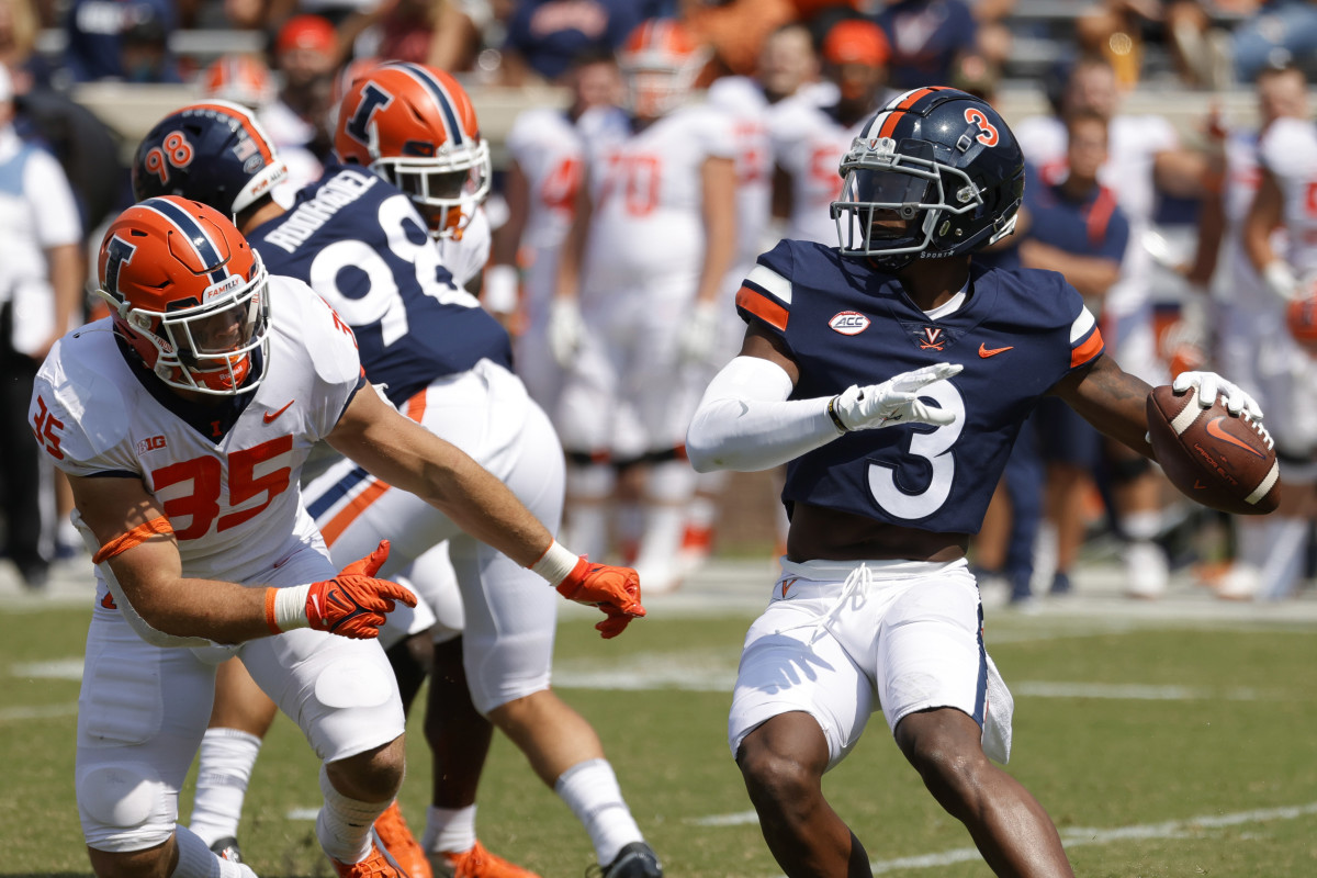 Virginia Cavaliers wide receiver Dontayvion Wicks (3) passes the ball as Illinois Fighting Illini linebacker Jake Hansen (35) chases in the third quarter at Scott Stadium.